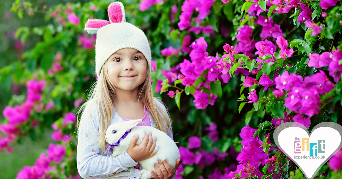 little girl wearing rabbit ears and holding an easter bunny