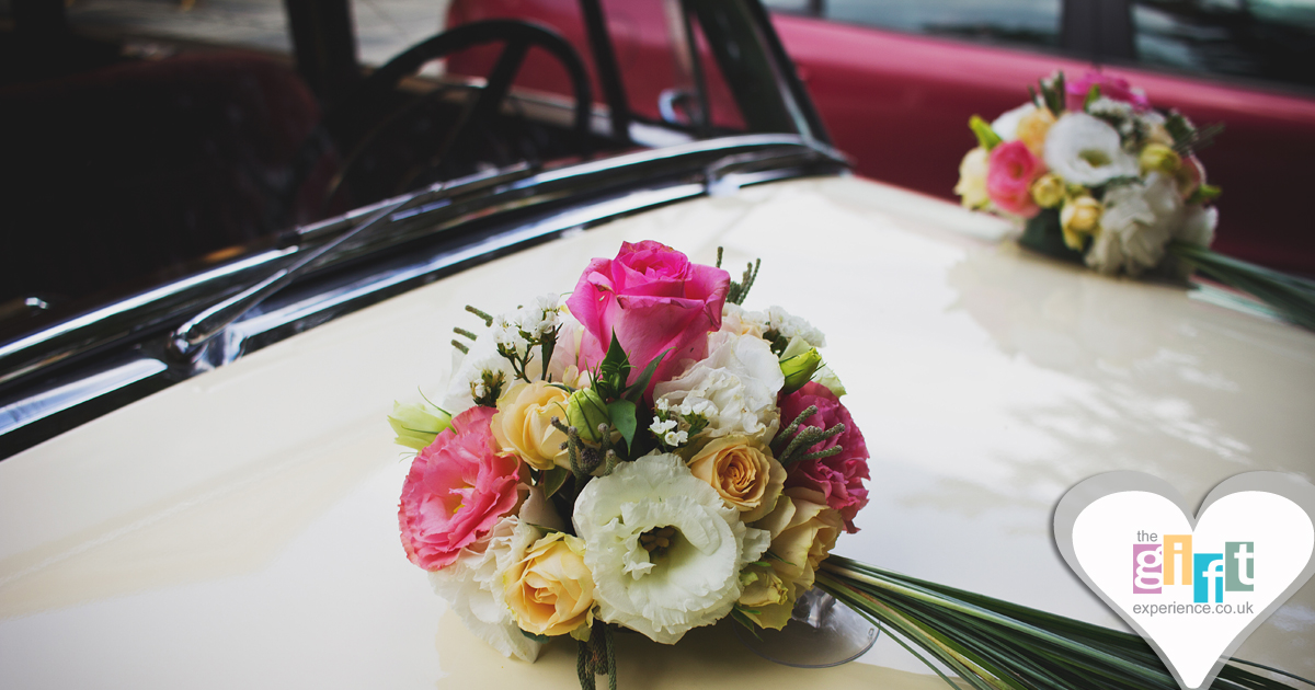 A wedding car with flowers on the bonnet